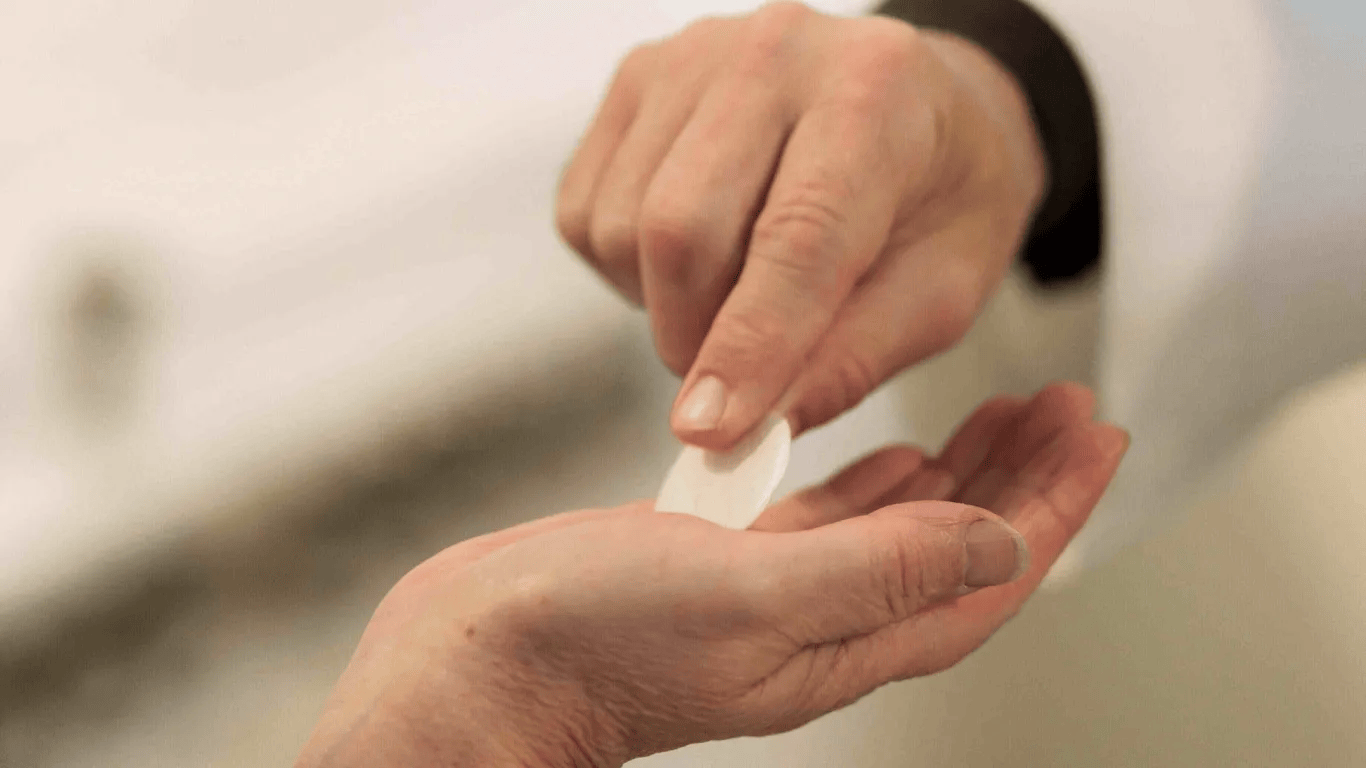 A young person placing a small donation into a charity box while reflecting on the joy of giving
