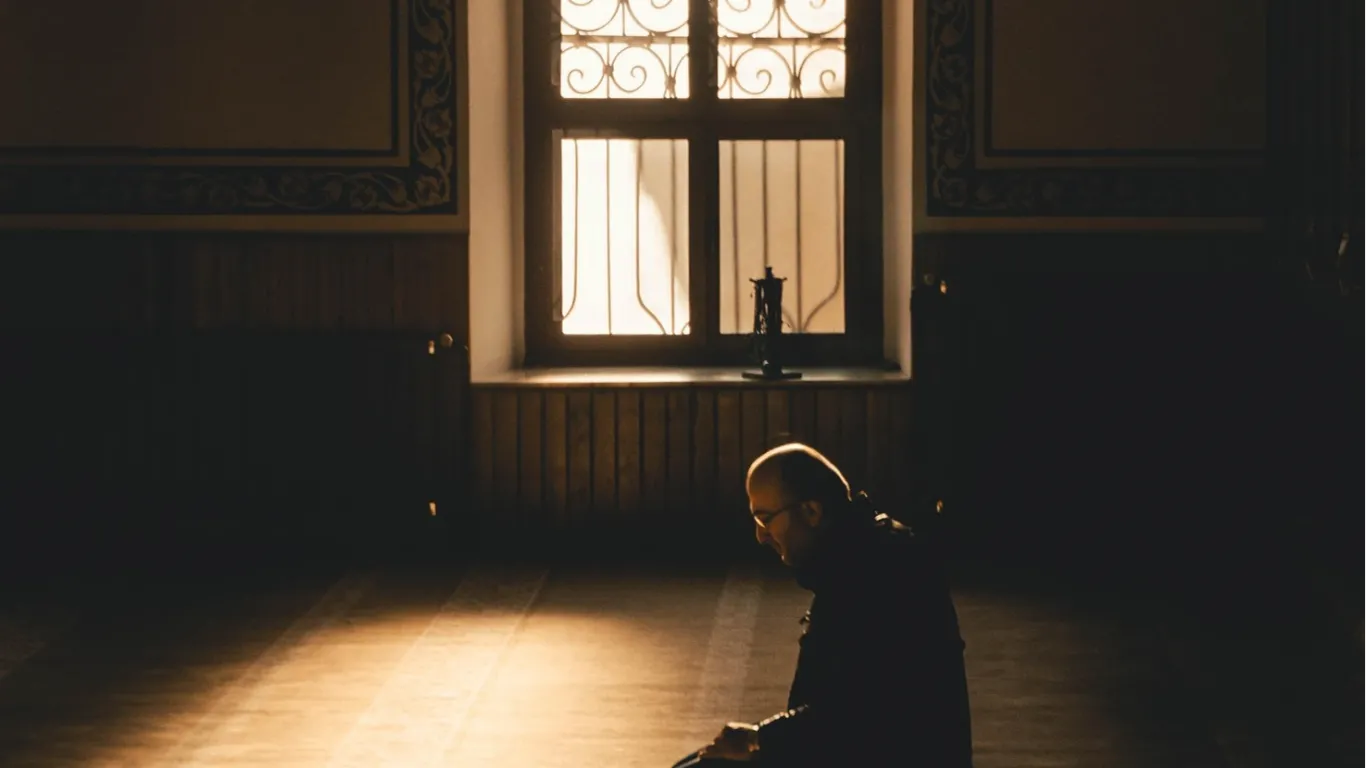 A person removing an obstacle from a pathway outside a mosque as an act of charity